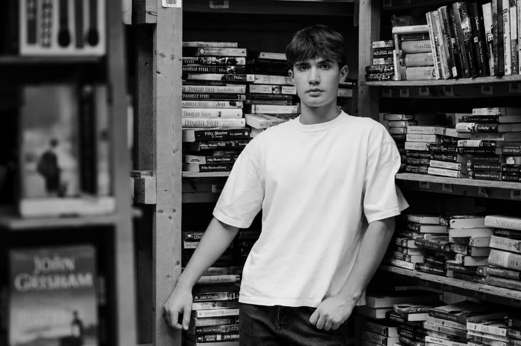 Nathan Carlson, standing between bookshelves